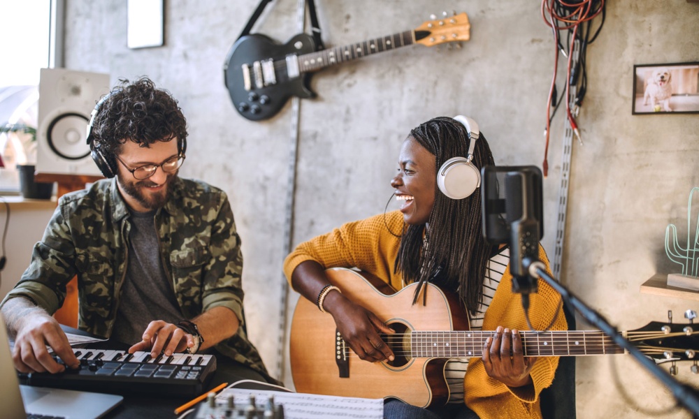 Two immigrants recording music together in a studio settings.