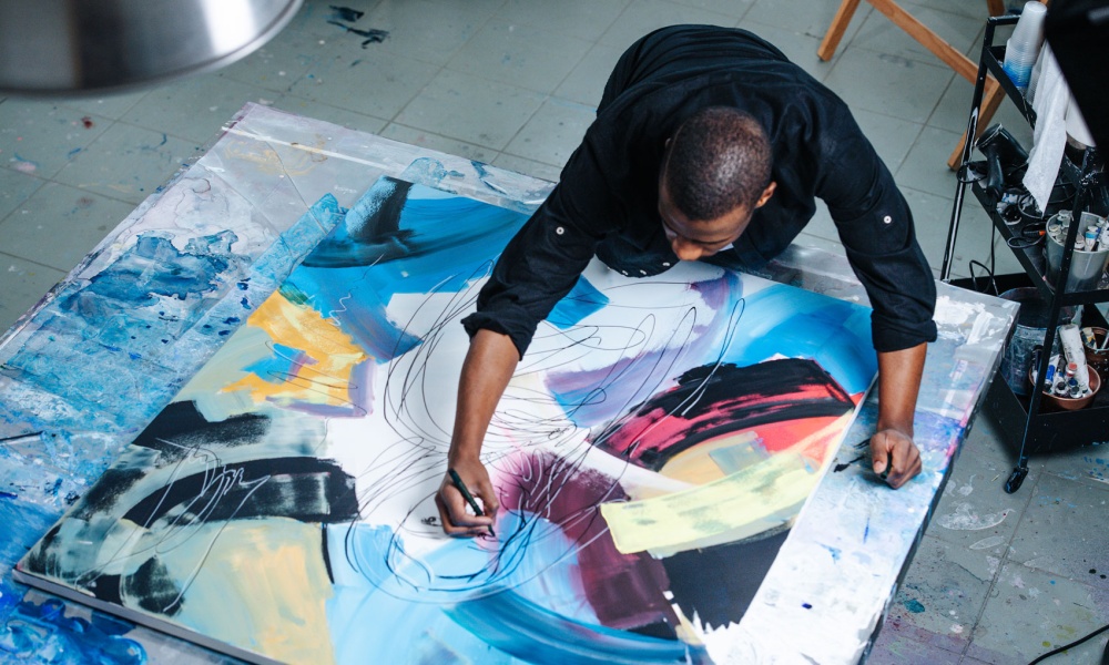 Artist immigrant working on a large canvas in his studio